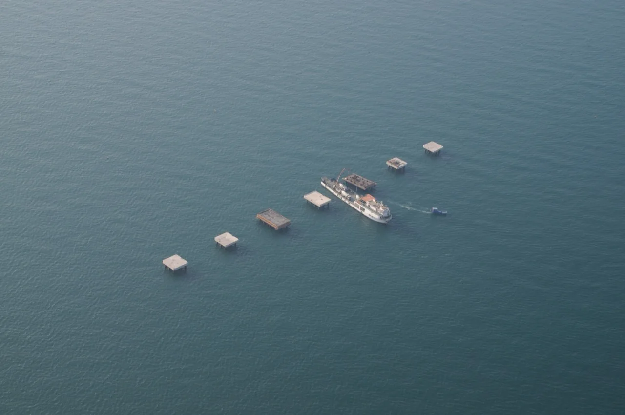 Aerial view of dolphin platforms and a work vessel at sea