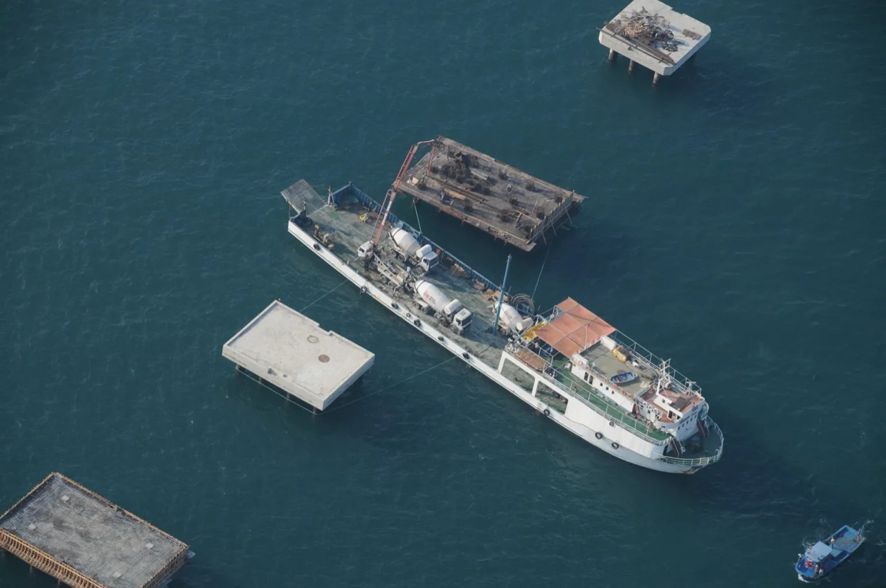 Aerial view of a vessel carrying out concrete work beside dolphin platforms